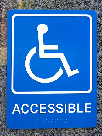 Accessibility Sign with Wheelchair, Accessible and Braille. [Photo Credit: LAtourist.com]