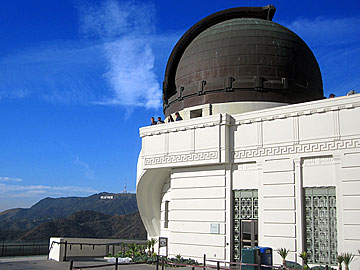 Griffith Observatory at Griffith Park in Los Angeles, California. The Hollywood Sign is in the background. [Photo Credit: LAtourist.com]