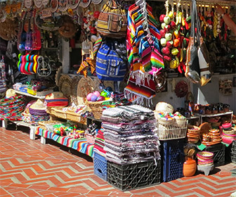 Shop on Olvera Street in Downtown L.A. with blankets, pottery, clothes and other Los Angeles souvenirs. [Photo Credit: LAtourist.com]